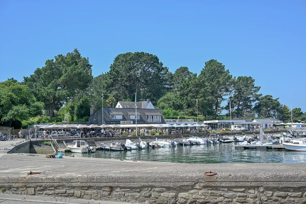 Petit port de l'Île aux Moines, bateaux amarrés et terrasses animées