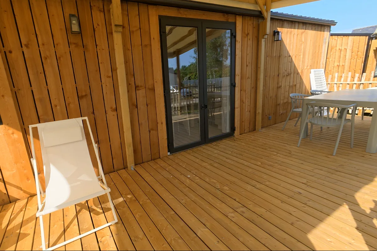 Terrasse en bois avec salon de jardin du mobil-home Premium 3 chambres — Camping Domaine du Morbihan