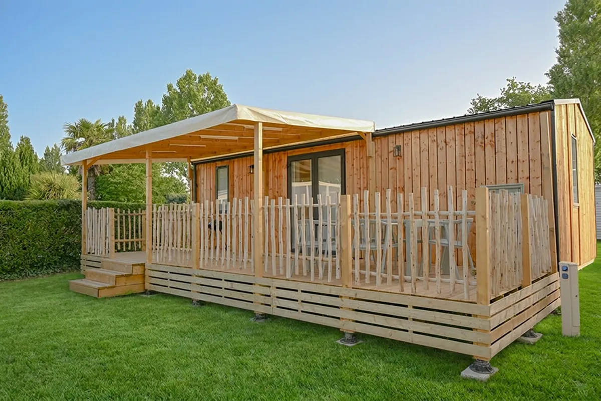 Mobil-home en bois sur pelouse avec terrasse couverte, camping Domaine du Morbihan