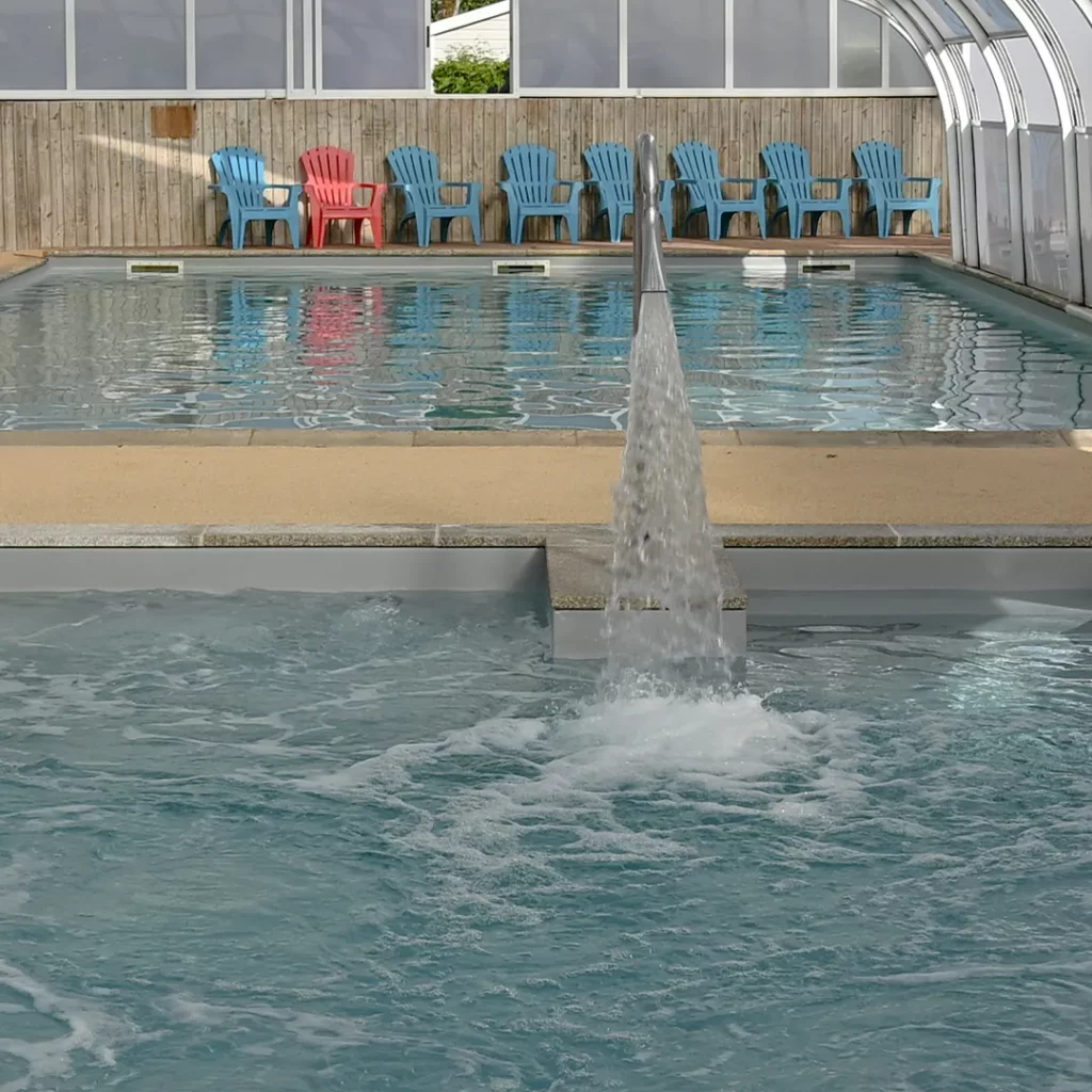 Gros plan sur le bassin balnéo bouillonnant devant la piscine couverte