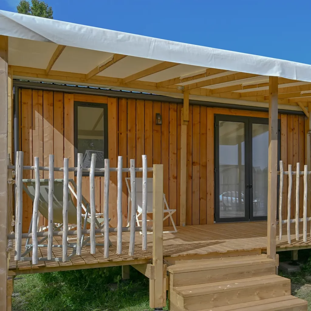 Chiliennes installées sur la terrasse couverte d'un mobil-home premium en bois