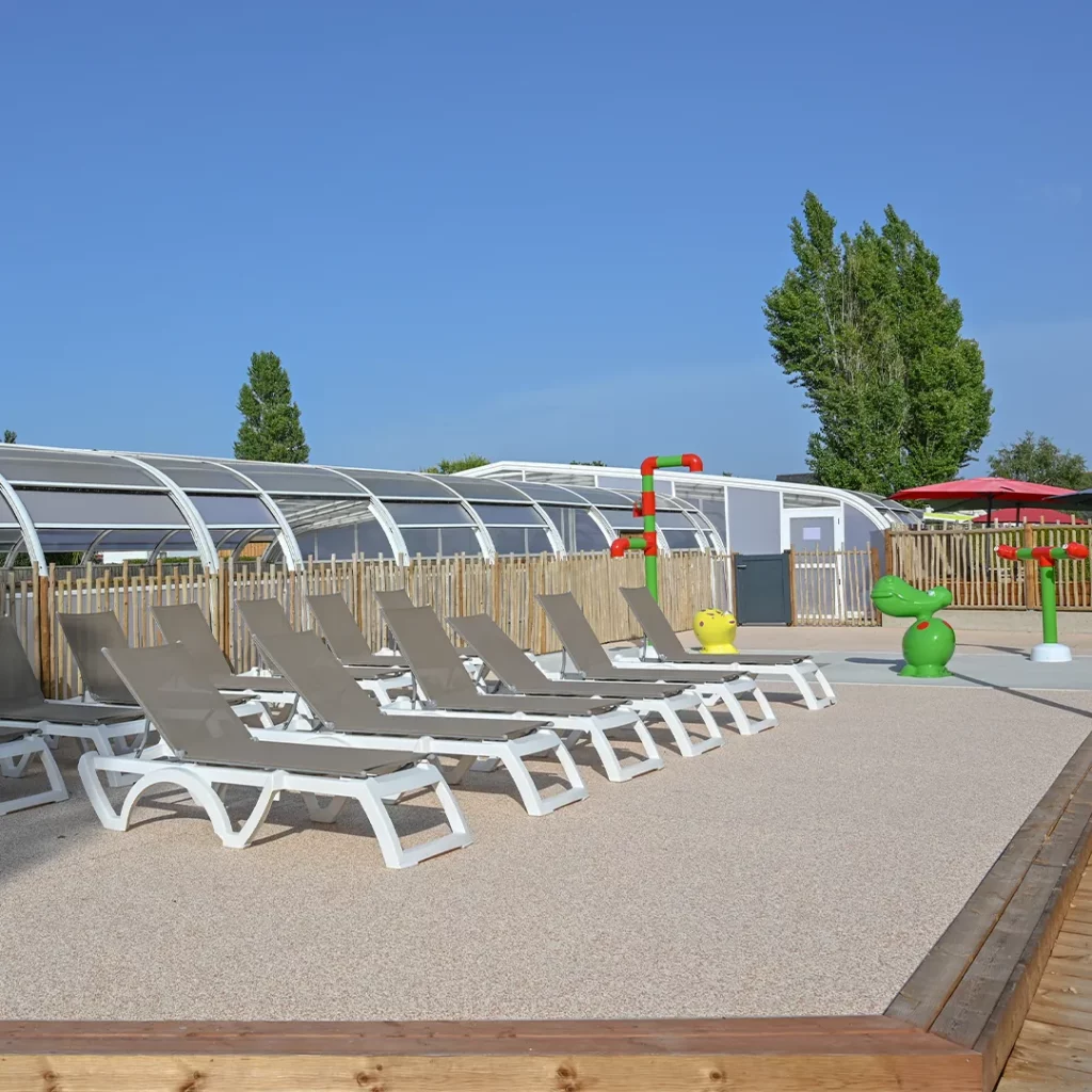 Transats alignés face aux jeux d'eau enfants, non loin du golfe du Morbihan