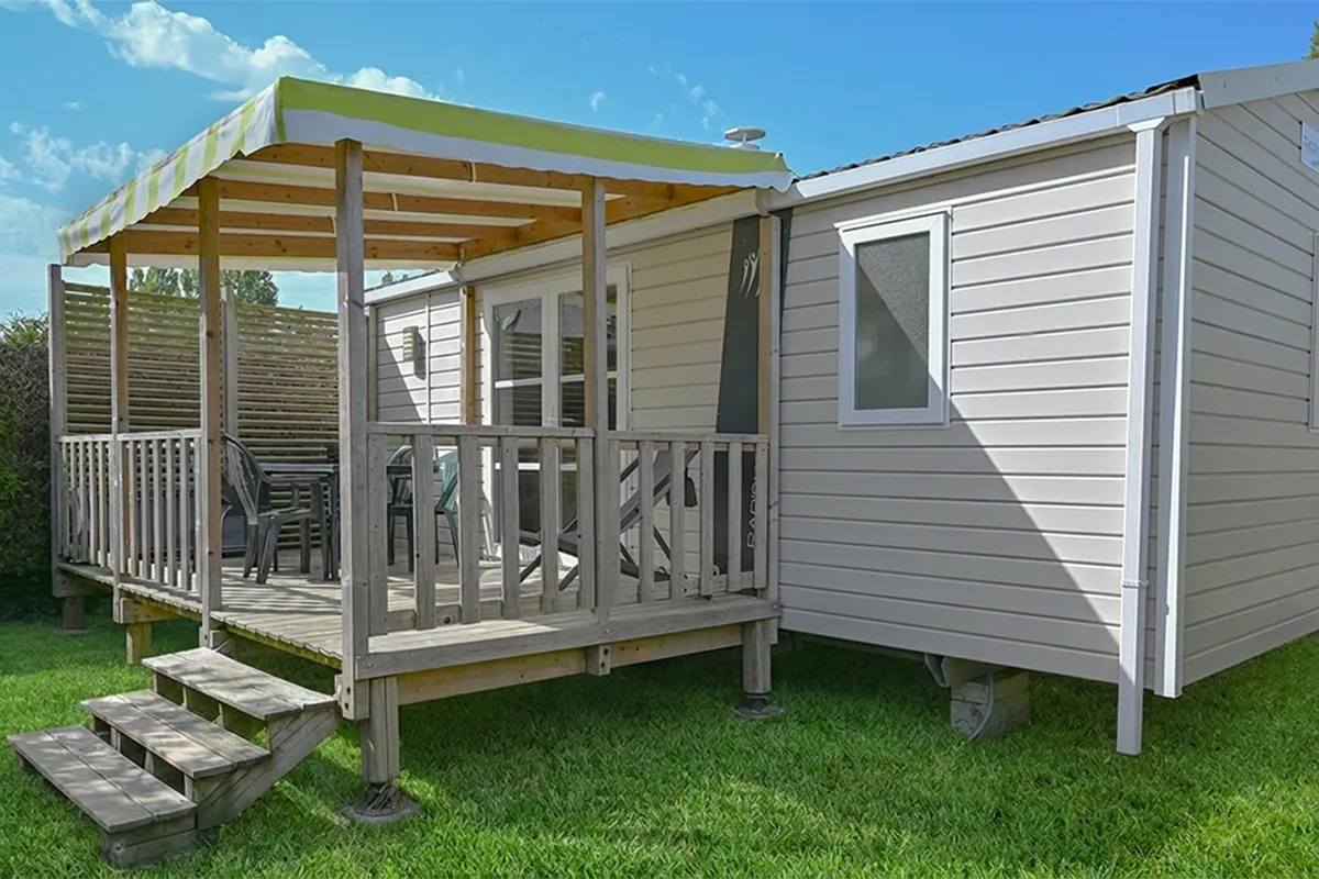 Mobil-home confort et sa terrasse en bois surélevée sur gazon, en Bretagne sud