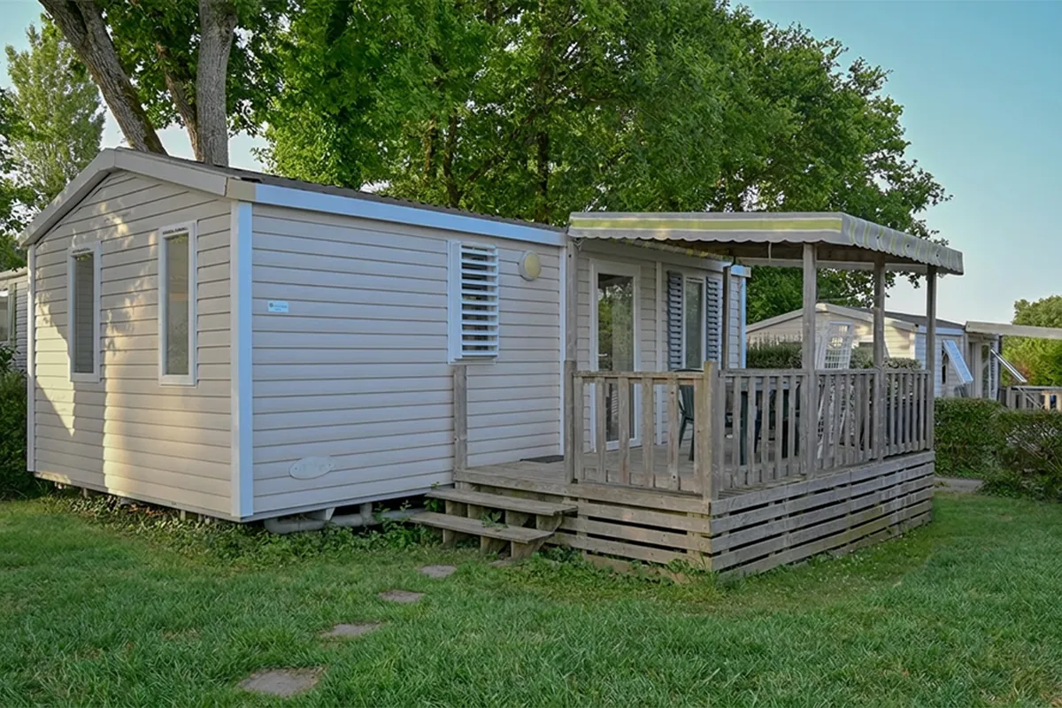 Mobil-home posé sur gazon, terrasse abritée avec salon de jardin, camping à Ambon